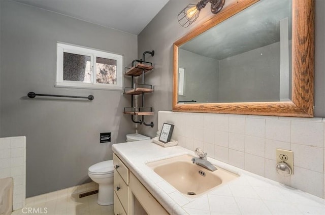 bathroom featuring tile patterned flooring, vanity, tasteful backsplash, and toilet