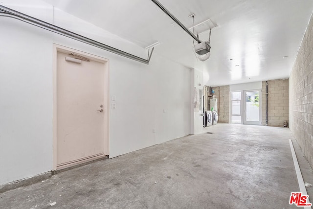 garage with washer and clothes dryer and a garage door opener