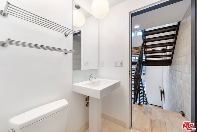 bathroom featuring sink, toilet, tile walls, and hardwood / wood-style flooring