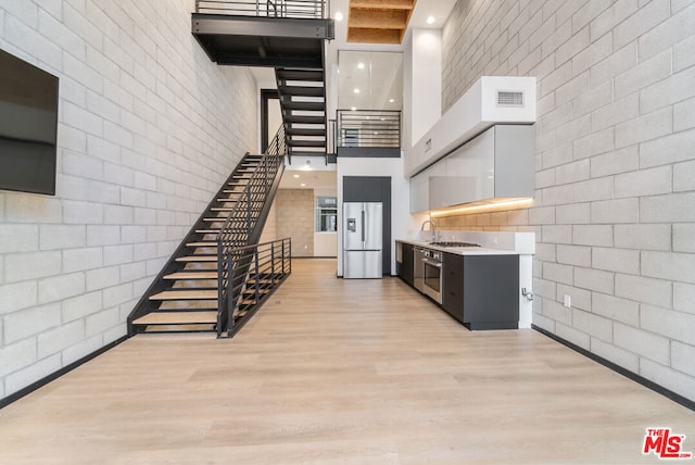 interior space featuring hardwood / wood-style flooring, a towering ceiling, and sink