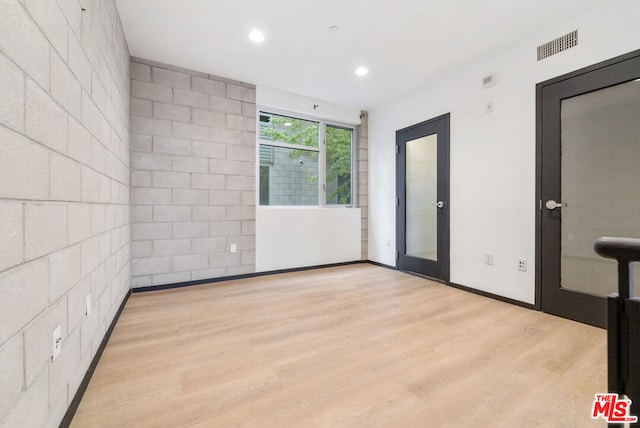 empty room featuring light wood-type flooring and french doors