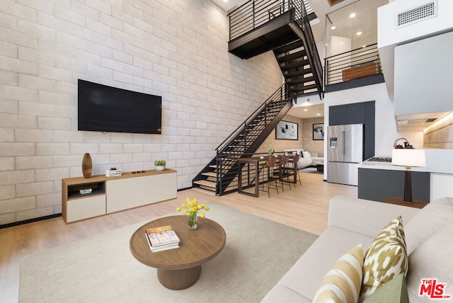 living room with wood-type flooring and a towering ceiling