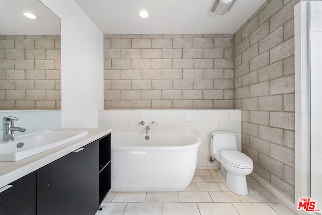 bathroom with tile patterned flooring, a bath, vanity, and tile walls