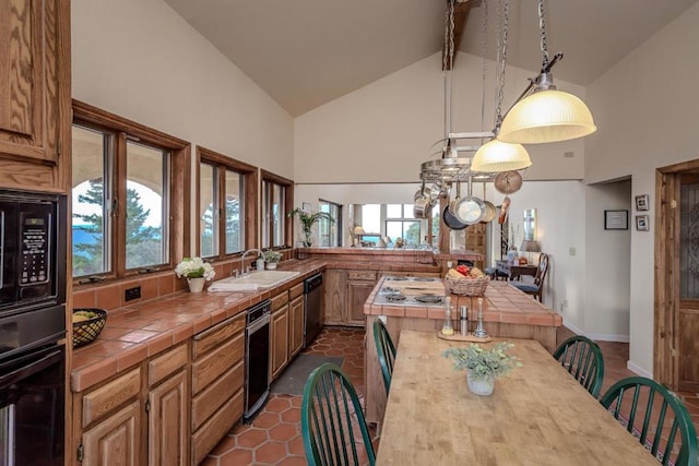 kitchen featuring tile countertops, plenty of natural light, black appliances, and high vaulted ceiling