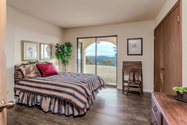 bedroom with access to exterior and dark wood-type flooring