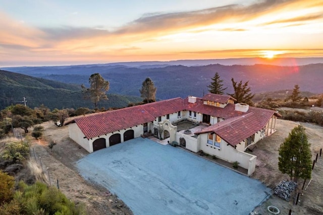 aerial view at dusk featuring a mountain view