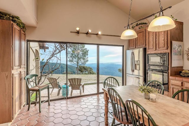 dining area with a mountain view and high vaulted ceiling