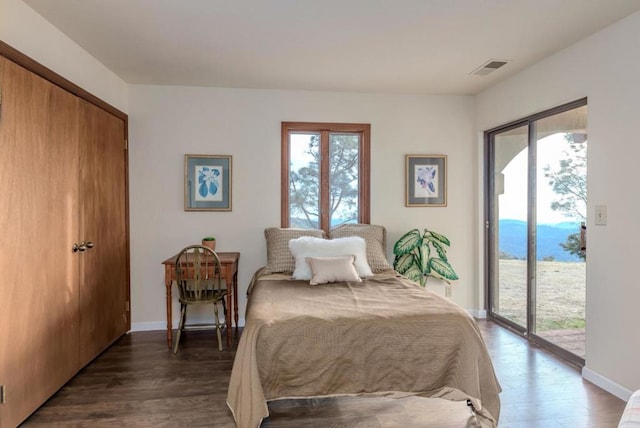 bedroom featuring access to outside, a closet, and dark wood-type flooring