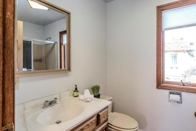 bathroom with an enclosed shower, vanity, and toilet