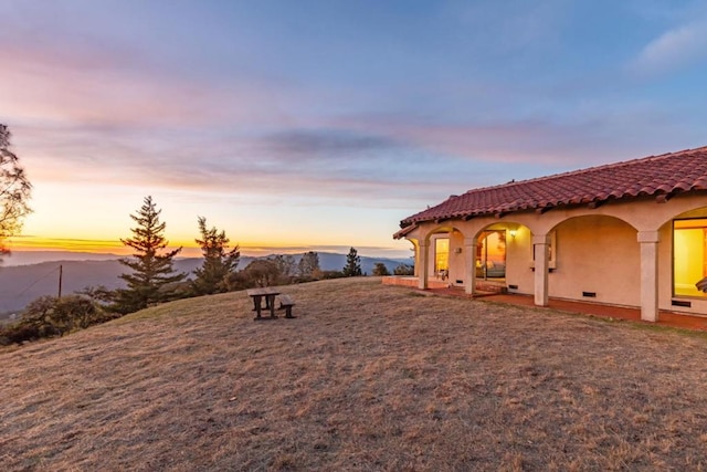 yard at dusk featuring a mountain view