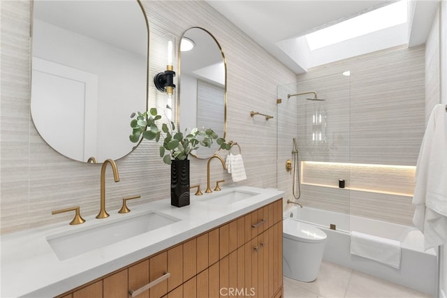 full bathroom featuring vanity, tiled shower / bath, a skylight, toilet, and tasteful backsplash