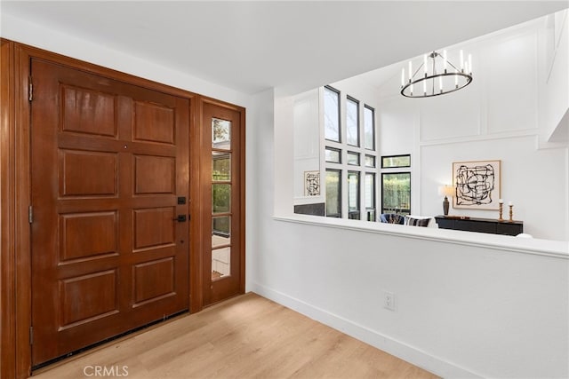 foyer entrance featuring light hardwood / wood-style flooring and a notable chandelier