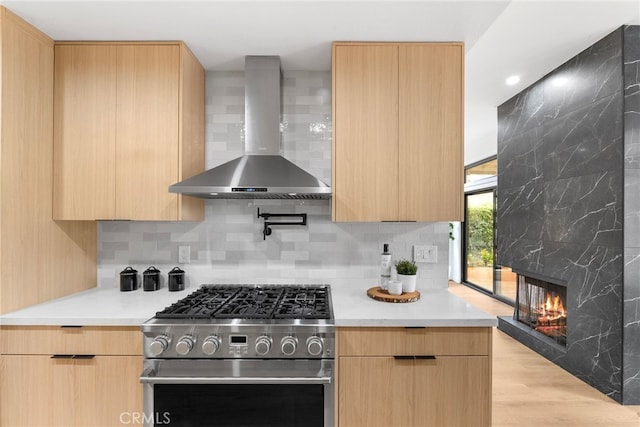 kitchen featuring light brown cabinets, high end stainless steel range, and wall chimney exhaust hood