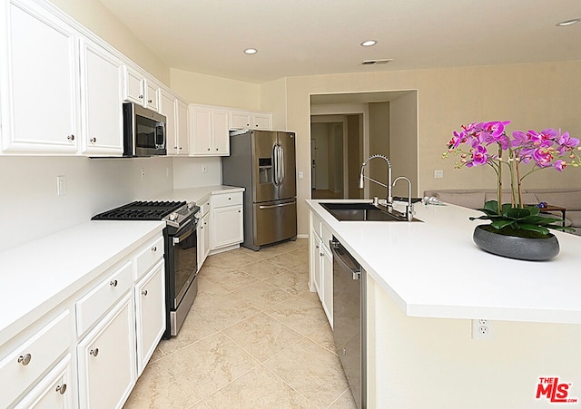 kitchen featuring sink, white cabinets, a center island with sink, and appliances with stainless steel finishes