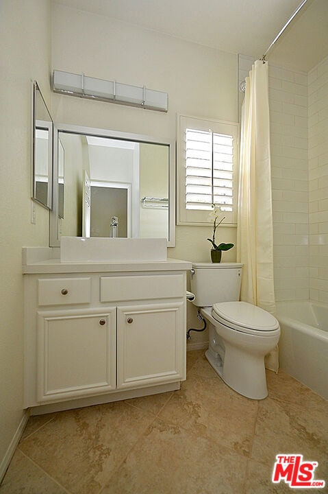 full bathroom with tile patterned flooring, vanity, shower / tub combo, and toilet