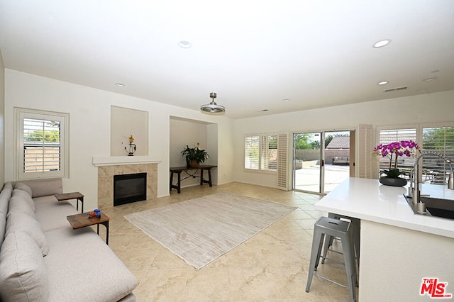 tiled living room featuring a tiled fireplace and sink