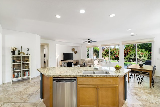 kitchen with ceiling fan, sink, stainless steel dishwasher, and a center island with sink