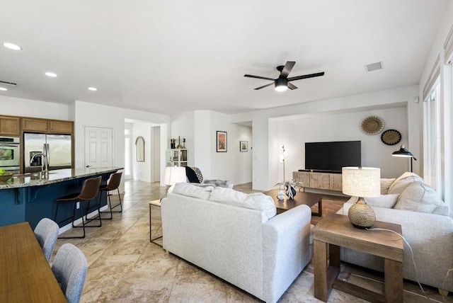 living room featuring ceiling fan and sink