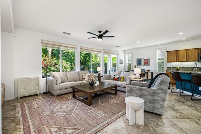 living room with ceiling fan and a healthy amount of sunlight