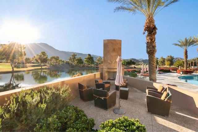 view of patio / terrace with a water and mountain view and an outdoor fireplace