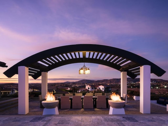 patio terrace at dusk with a mountain view and an outdoor fire pit