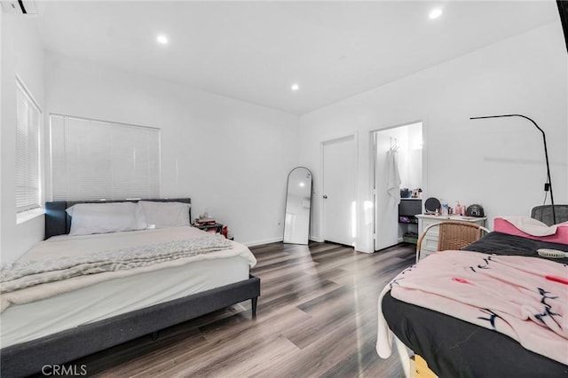 bedroom featuring hardwood / wood-style floors and a wall mounted air conditioner