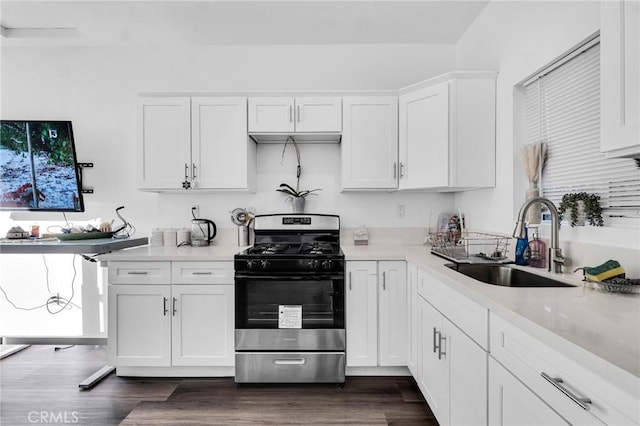 kitchen featuring dark wood-type flooring, sink, gas stove, and white cabinetry