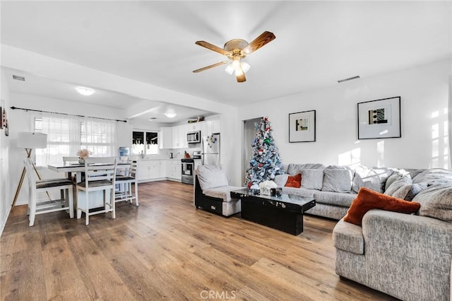 living room with ceiling fan and hardwood / wood-style flooring