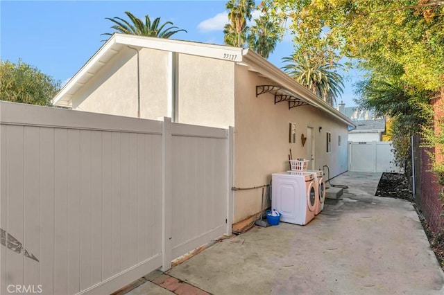 view of property exterior featuring a patio area and washer / clothes dryer