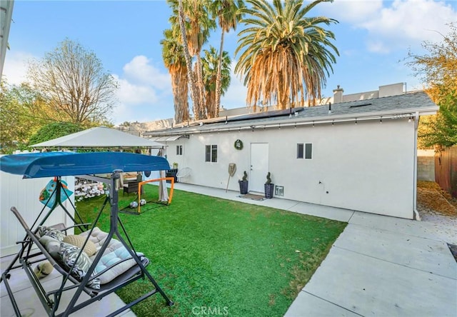 back of property featuring a lawn and a patio