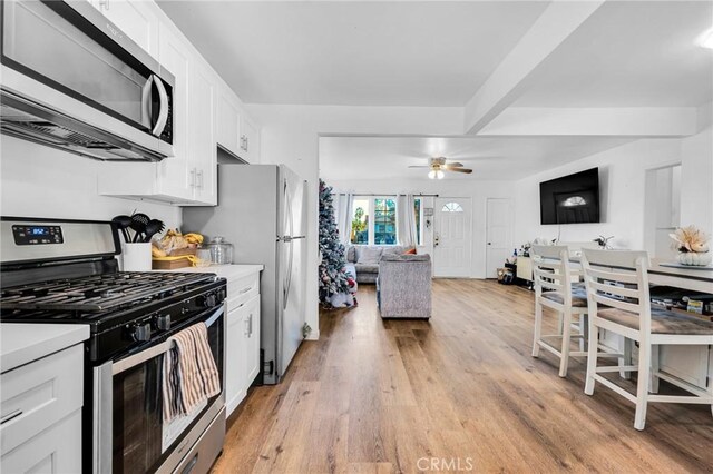 kitchen featuring ceiling fan, white cabinets, appliances with stainless steel finishes, and light hardwood / wood-style flooring