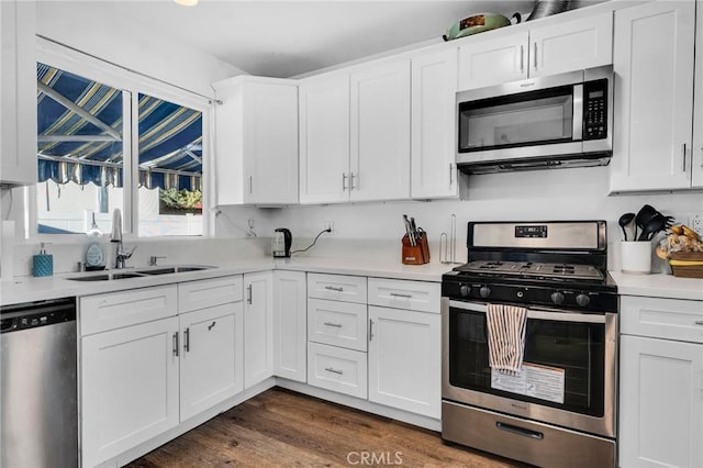 kitchen with dark hardwood / wood-style floors, sink, stainless steel appliances, and white cabinetry