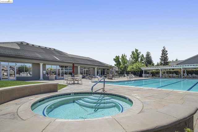 view of swimming pool featuring a patio and a community hot tub