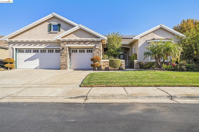 view of front of property featuring a garage, a front lawn, and solar panels