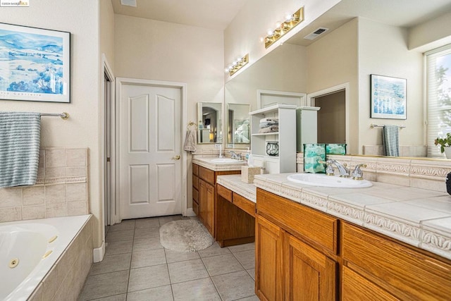 bathroom featuring tile patterned floors, tiled bath, and vanity