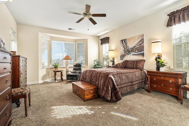 bedroom with multiple windows, light colored carpet, and ceiling fan