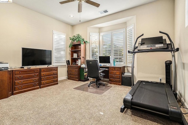 carpeted office space featuring ceiling fan