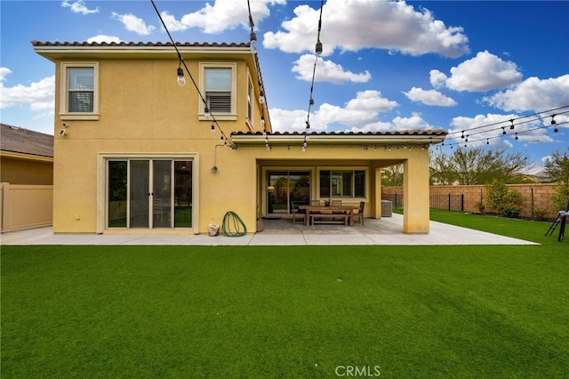 back of property featuring a lawn and a patio area