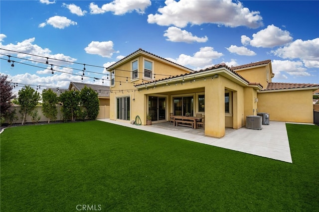 rear view of property featuring a lawn and a patio area