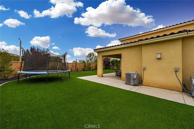 view of yard featuring a trampoline, a patio, and cooling unit