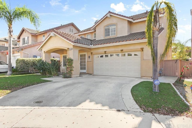 mediterranean / spanish house with a garage and a front yard