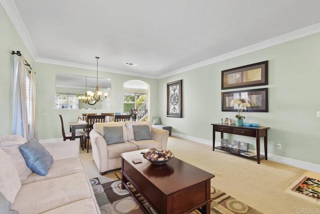 living room with light colored carpet, ornamental molding, and a chandelier