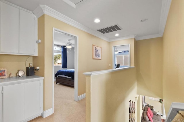 hallway with crown molding and light colored carpet