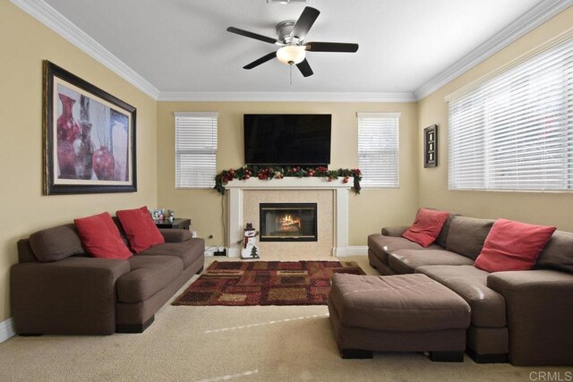 living room featuring carpet, a fireplace, ceiling fan, and crown molding