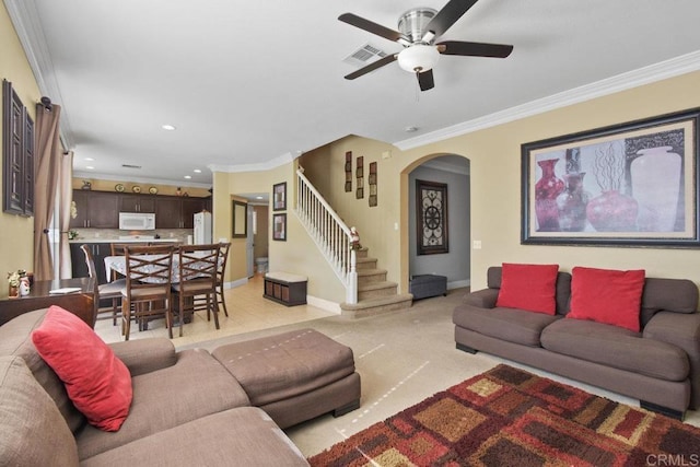 carpeted living room featuring ceiling fan and ornamental molding