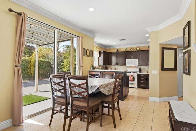 dining area featuring light tile patterned floors and crown molding