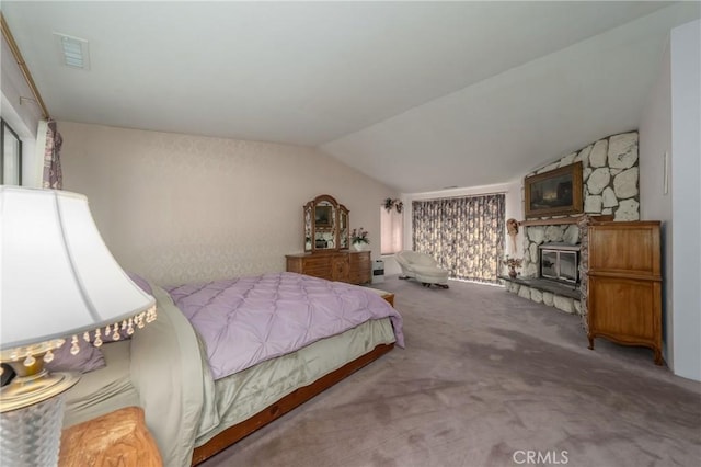 bedroom with vaulted ceiling, a fireplace, visible vents, and carpet floors