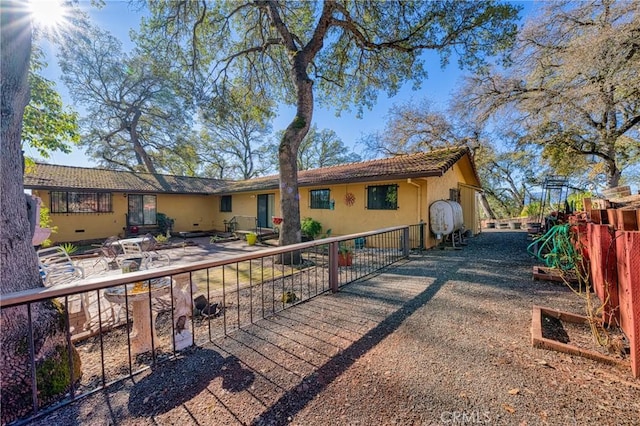 back of house featuring stucco siding, a patio, and fence