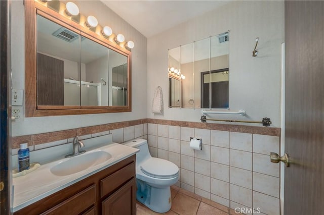 bathroom with visible vents, toilet, tile walls, and tile patterned flooring
