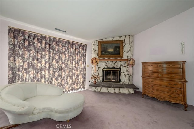 living area with visible vents, carpet flooring, a stone fireplace, and lofted ceiling